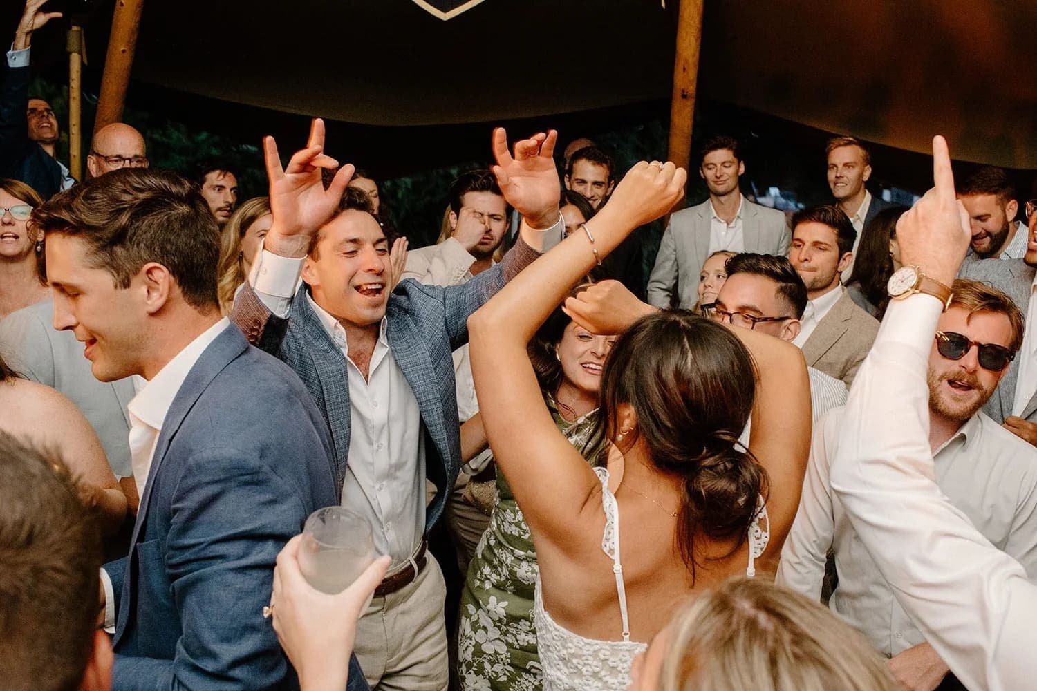 A lively group of people dances joyfully at a celebration.