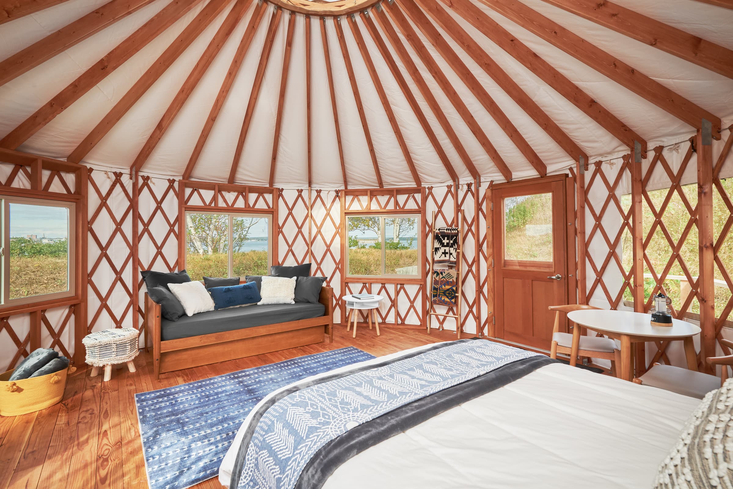 Cozy interior of a yurt featuring a bed, seating area, and wooden accents.
